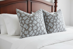 Silver Pebble Leopard Pillows on White Bed with Mahogany Headboard